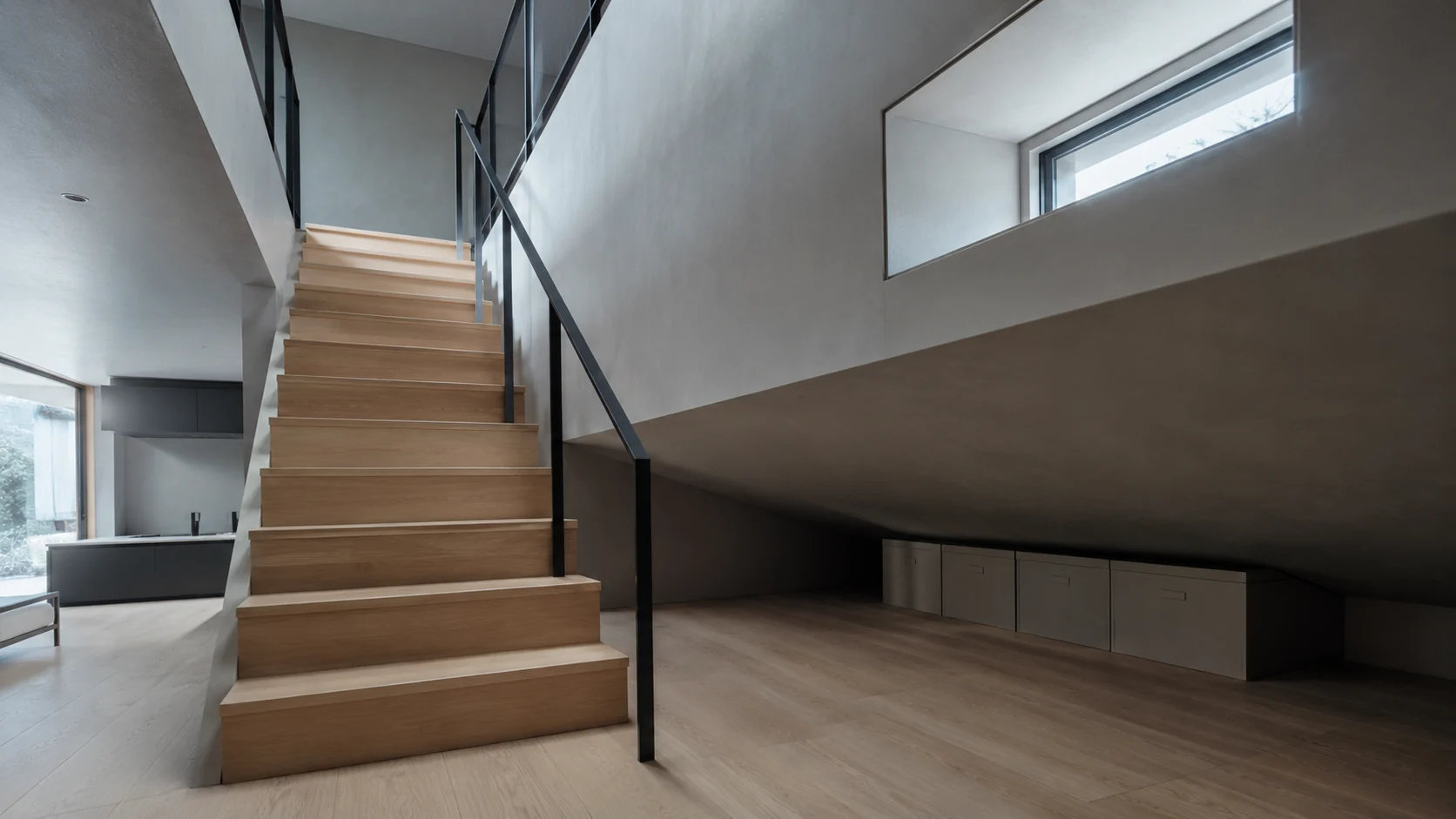 勾配天井の下の小屋裏収納。開口の落下側に手すりを立てた固定階段が続く