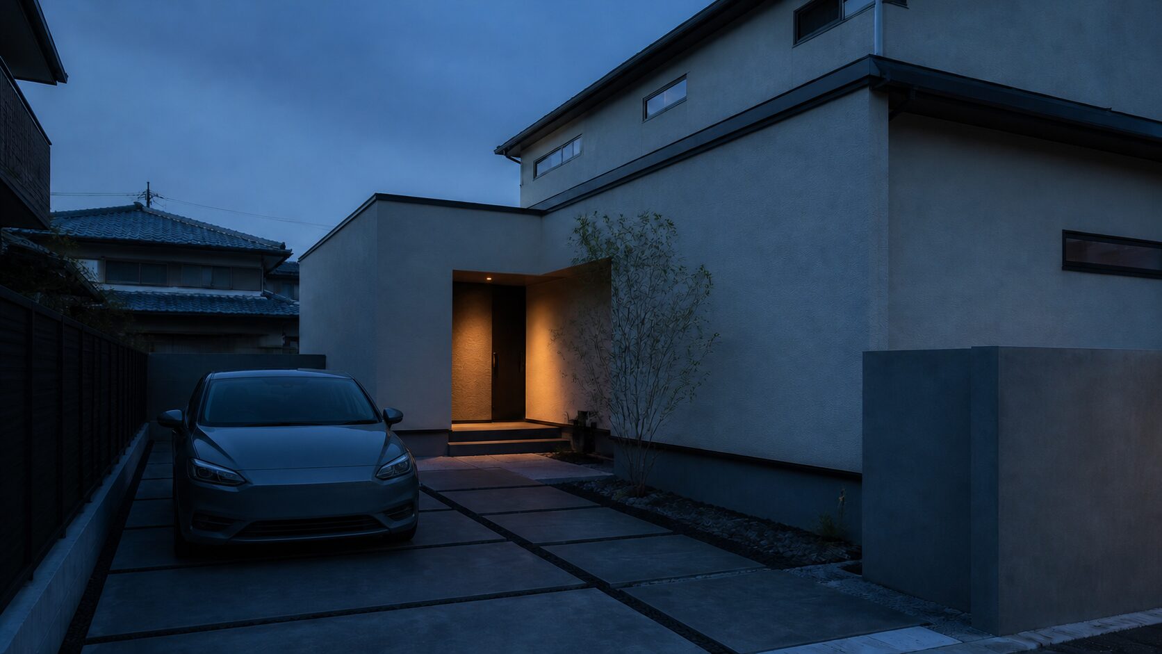 車を停めた位置から玄関までの歩行経路が読める、夕暮れの戸建て駐車スペース